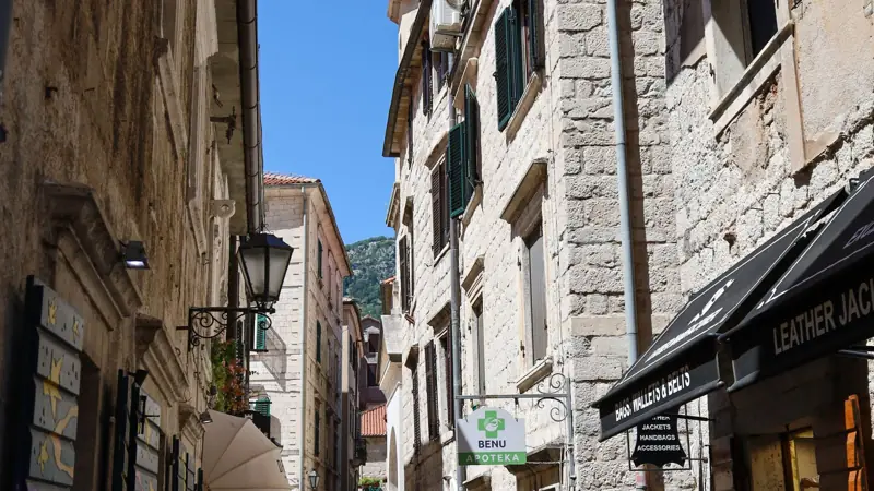 A stone street in Kotor's old town with mountains behind