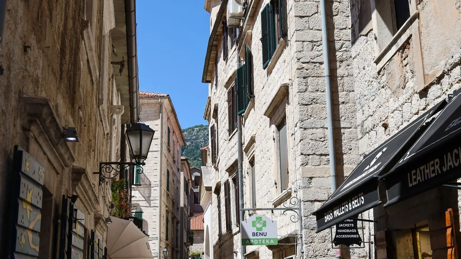 A stone street in Kotor's old town with mountains behind