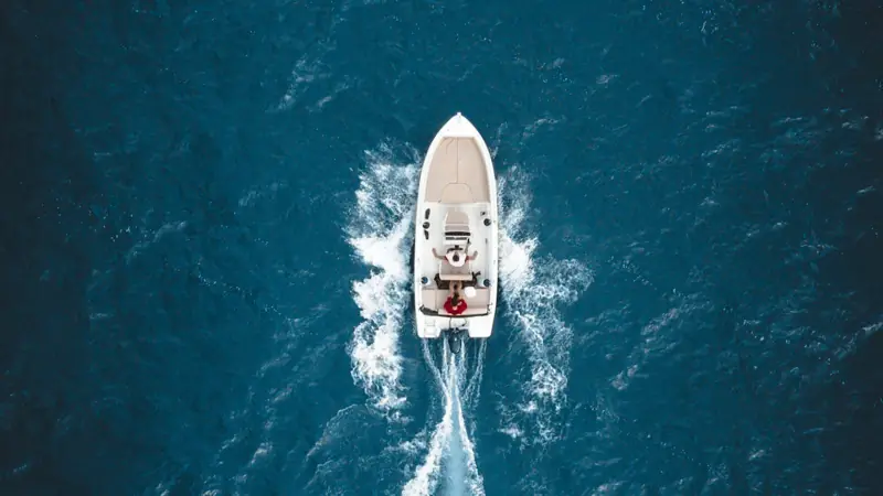 A white speedboat seen from above on the deep blue sea near Tivat